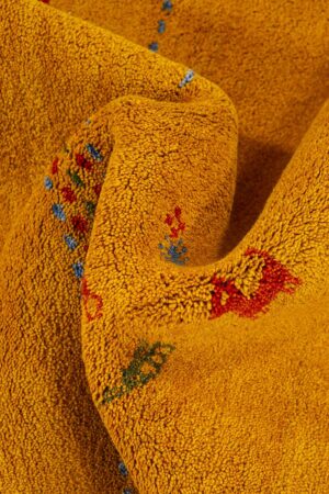 שטיח כפרי מלבני מצמר בגוון צהוב המתאים במיוחד למשרד או פינת אוכל עם עיטורים צבעוניים